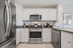 Enjoy cooking in this well-equipped kitchen with stainless steel appliances and ample counter space.