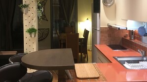 Cocina compacta con comedor, que incluye una mesa redonda, sillas y una pequeña isla con pileta.