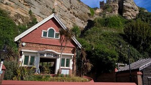 A red brick building with a white trim and a sign reading "East Hill Lift". - Location Location! Spacious 2 Bed Apt Hastings - Country & Sea Views (Hastings)