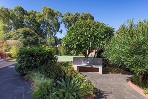 A paved walkway with a bench, surrounded by various plants and trees. - Home2Book Luxury Villa Luna de Tacoronte Pool (San Cristóbal de La Laguna)