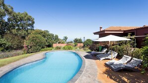 Une piscine avec des chaises longues et un espace patio.