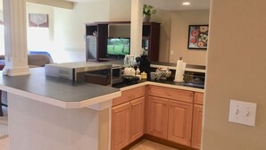 A modern kitchen with a built-in microwave, coffee maker, and a small refrigerator. - Spread out in a large,1600 sq foot comfort suite 1 bedroom plus additional nook (Longmont)