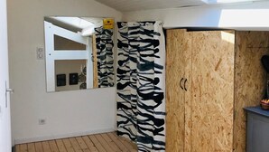 A room with a skylight, wooden flooring, a mirrored wardrobe, and zebra-patterned curtains. - Maisonette with terrace 5 minutes from the beaches (Anglet)