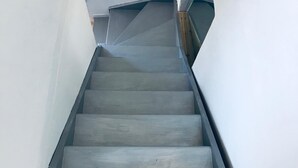 A staircase with a wooden handrail and a plain white wall on one side. - Maisonette with terrace 5 minutes from the beaches (Anglet)