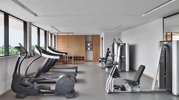 Un gimnasio moderno con cintas de correr, elípticas y equipo de pesas.