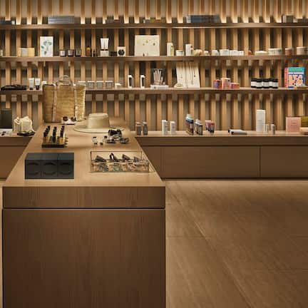A modern interior with wooden paneling and shelves displaying various products.