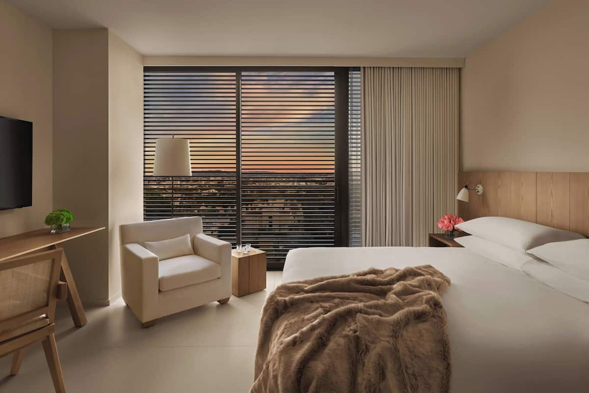 Een moderne hotelkamer met een groot bed, een bureau, een stoel en een televisie.