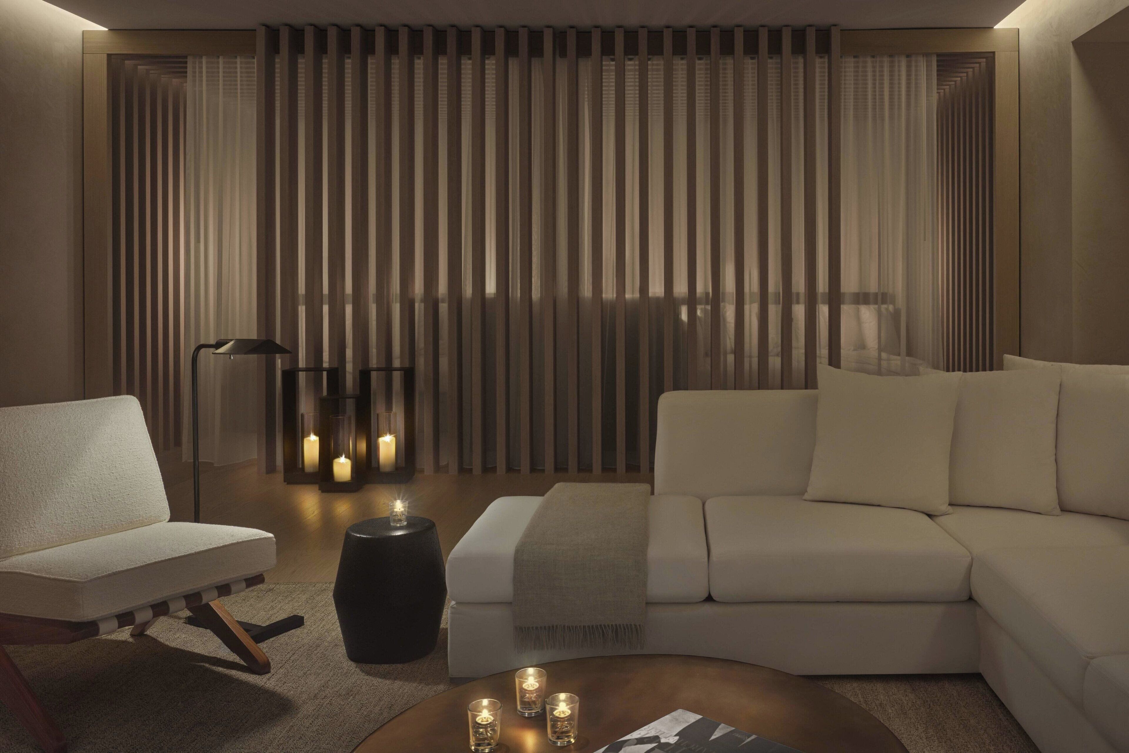 A modern living room with a sofa, a chair, a coffee table, and a floor lamp.
