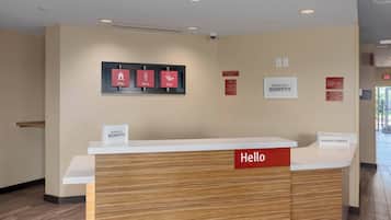 Una recepción de hotel con un letrero que dice 'Hello', un letrero que dice 'Stay' y un letrero que dice 'Play' encima.