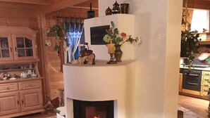 Une cheminée moderne, avec un manteau en pierre, des meubles en bois et des objets décoratifs disposés sur l’étagère.