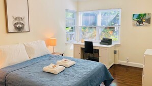 Ein Hotelzimmer mit Bett, Schreibtisch und einem Fenster mit Jalousien.