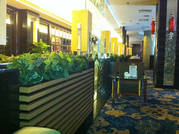 A lobby with a reception desk, a plant wall, and a patterned carpet. - Xiangtan Chengyuan Hotel (Xiangtan)