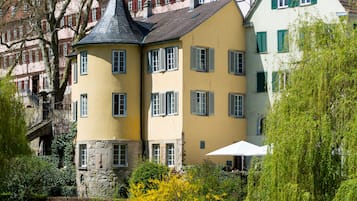 Ein historisches Gebäude mit steilem Dach, zahlreichen Fenstern und einem markanten Turm.