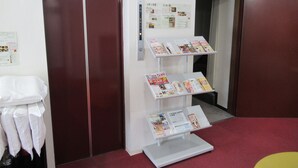 A hotel lobby with a reception desk, a bulletin board with notices, and a magazine rack. - Hotel Crown Hills Kitami Annex (Kitami)