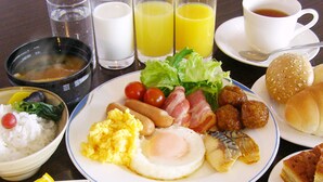 A breakfast plate with scrambled eggs, bacon, sausages, and vegetables. - Hotel Crown Hills Kitami Annex (Kitami)