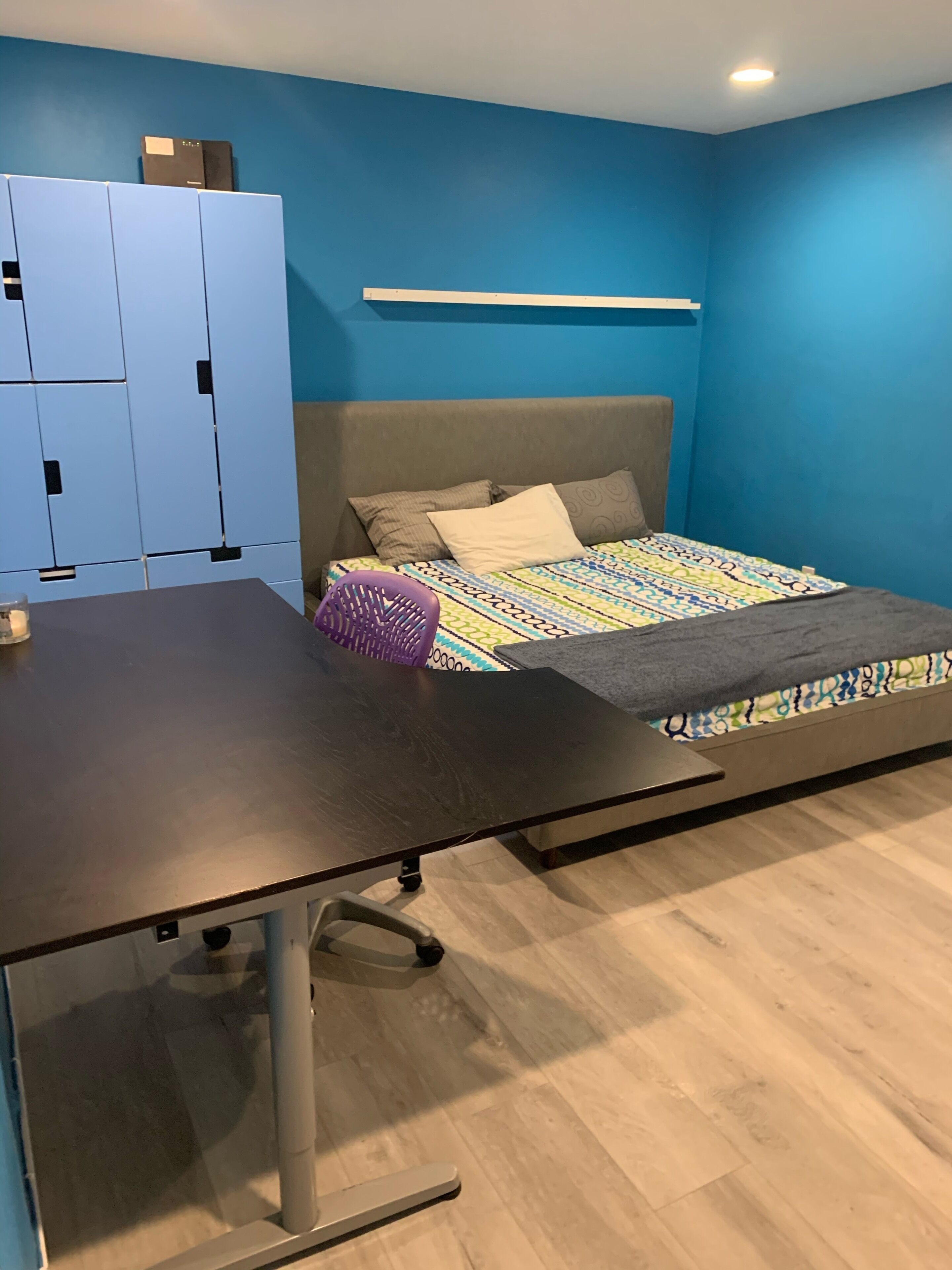 A room with a bed, a desk, and a wardrobe.