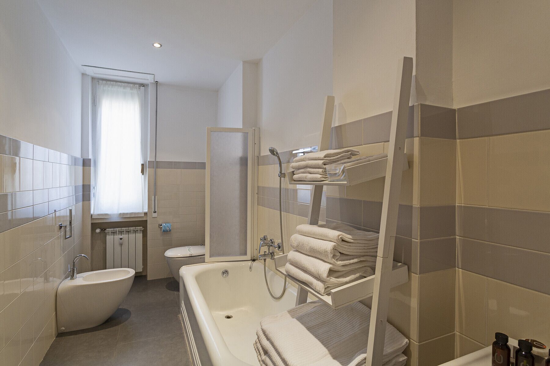 Een moderne badkamer met een badkuip, een aparte douche en een toilet.