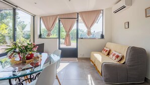 Una habitación con una mesa de vidrio, un sofá y vistas a través de una puerta.