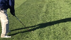A person on a golf course with a view of the ocean.