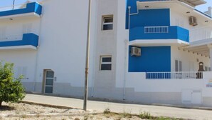 A multi-story building with a white and blue exterior, balconies, and air conditioning units. - Apartment Brezza by Interhome (Scicli)