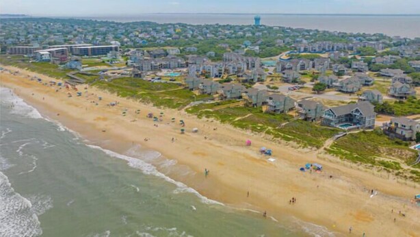 Zona residencial costera con propiedades frente al mar y una playa.