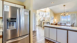 Una cocina moderna con un refrigerador de acero inoxidable, un dispensador de agua integrado y una isla central con asientos.