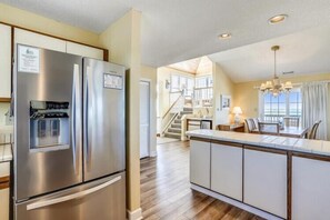 A modern kitchen with a stainless steel refrigerator, a built-in water dispenser, and a central island with seating.