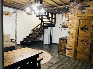 Ein rustikales Interieur mit einer Holztreppe, einem runden Tisch und einer Tür im rustikalen Stil.