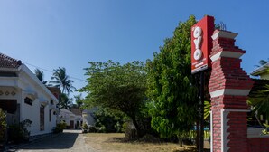 A hotel entrance with a red brick pillar and a sign.