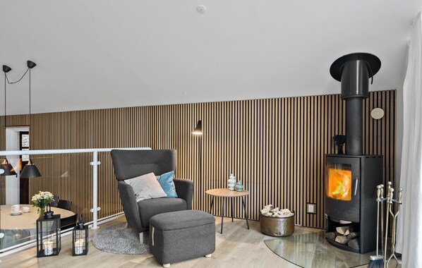 A modern living room with a sofa, a round table, a floor lamp, and a wood-burning stove. - 3 bedroom nice home in Egernsund (Egernsund)