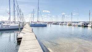 En lysthavn med flere sejlbåde fortøjet langs en træbrygge.