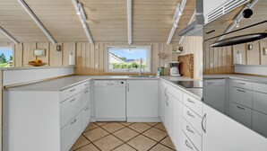 A compact kitchen with white cabinetry, a window with a view, and a tiled floor. - 3 bedroom amazing home in Haderslev (Haderslev)