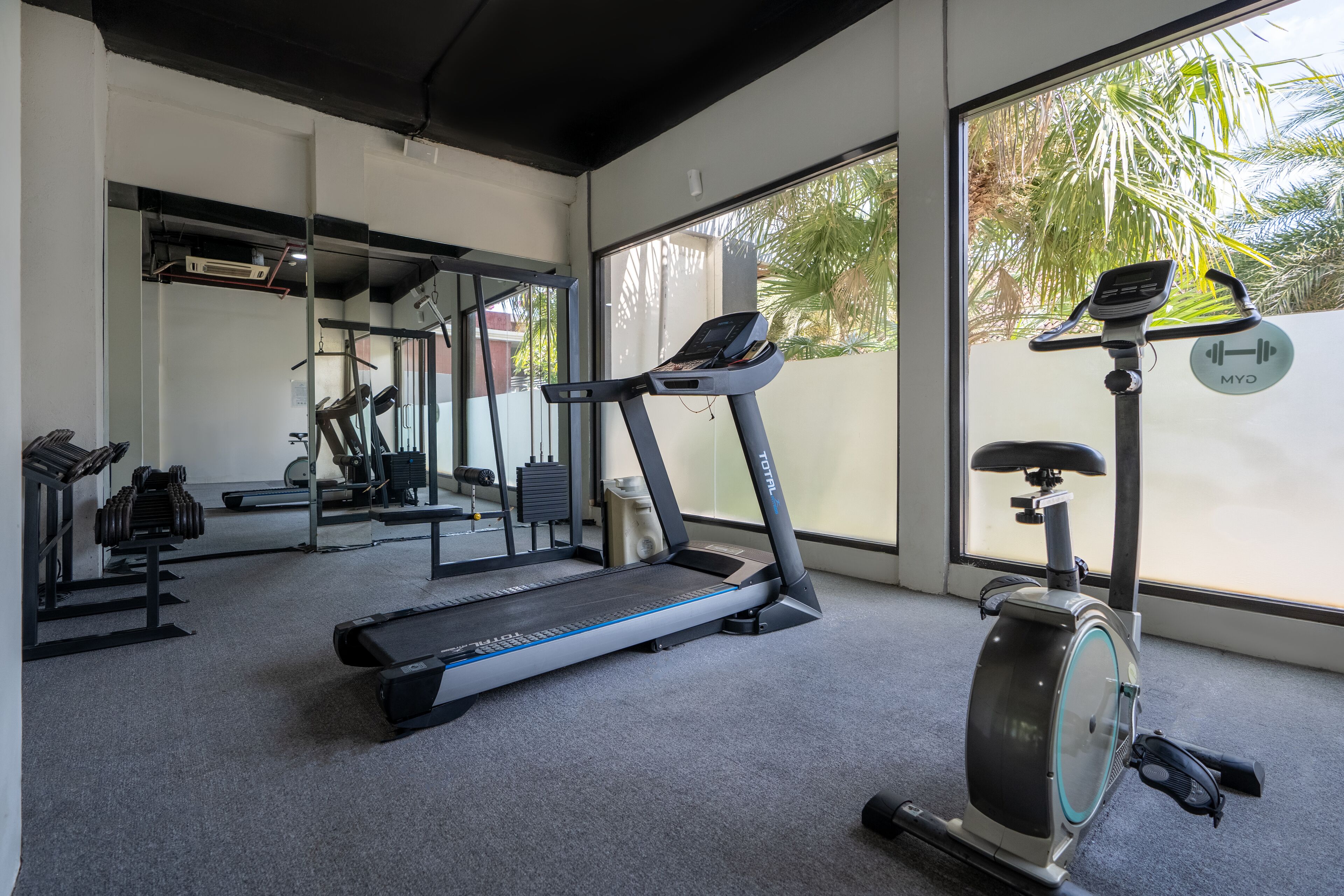 A gym with treadmills, an elliptical, and free weights.