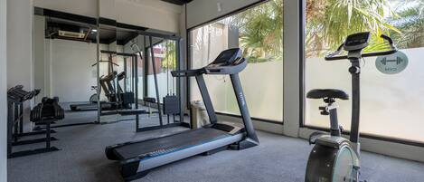 A gym with treadmills, an elliptical, and free weights.