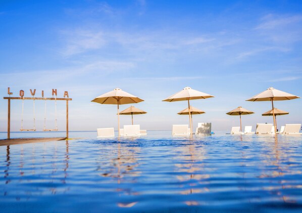 Een buitenzwembad en ligstoelen