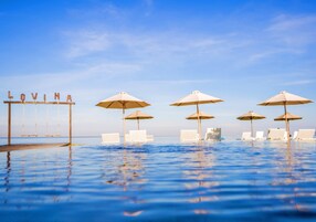 Una piscina al aire libre, sillones reclinables de piscina