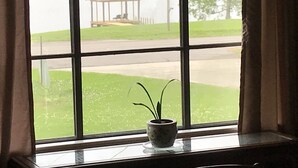 A window with a view of a gazebo and a grassy area.