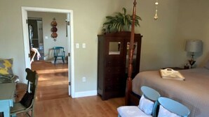 A bedroom with a bed, a dresser, a chair, and a desk.