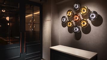 A modern interior with a wall-mounted light fixture and a dark wooden door.