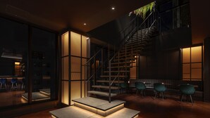 Un interior moderno con una escalera, una zona de estar y vistas al exterior.