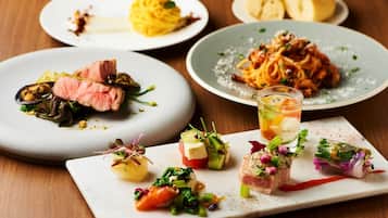 A variety of dishes on plates, including pasta, steak, and appetizers.