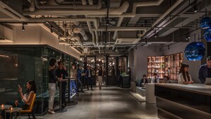 Un interior moderno con una zona de bar, asientos y una recepción.