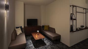 A modern living room with a sectional sofa, a flat-screen TV, a coffee table, and a built-in shelf with decorative items.