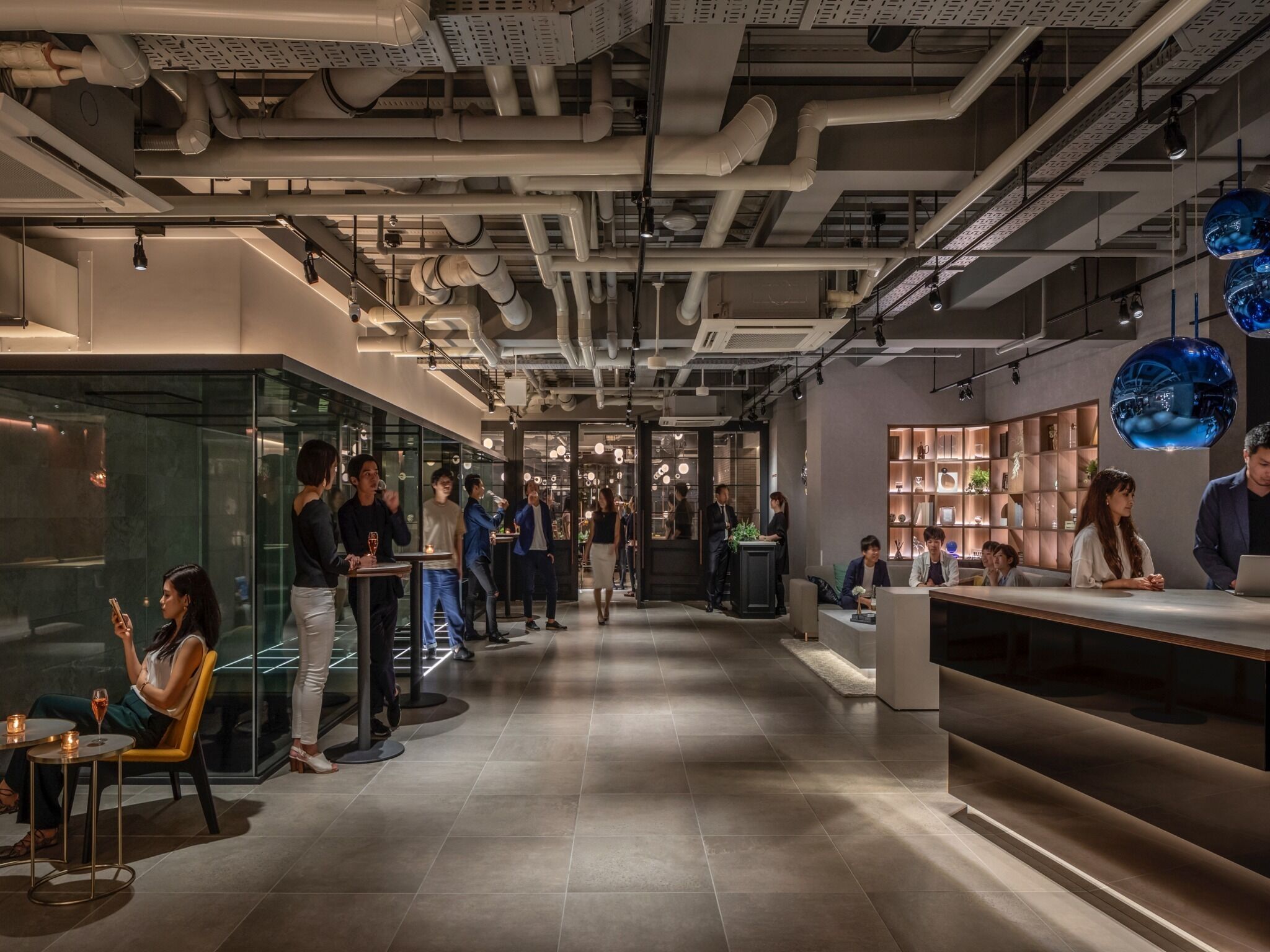A modern interior with a central corridor, glass partitions, and a reception area with a counter.
