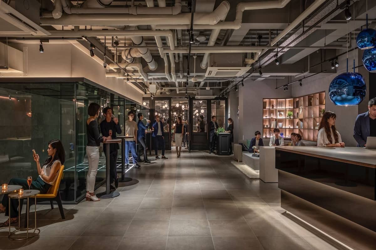 A modern interior with a central corridor, glass partitions, and a reception area with a counter.