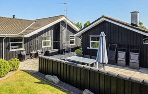 A two-story house with a patio area, a table, chairs, and an umbrella. - Stunning home in Storvorde with kitchen (Storvorde)