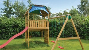 A wooden play structure with a slide and swings in a grassy area. - Stunning home in Storvorde with kitchen (Storvorde)