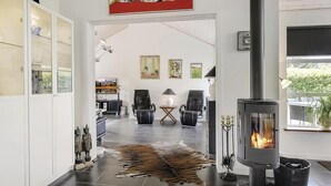 A modern living room with a fireplace, leather chairs, a rug, and artwork on the walls. - Stunning home in Storvorde with kitchen (Storvorde)