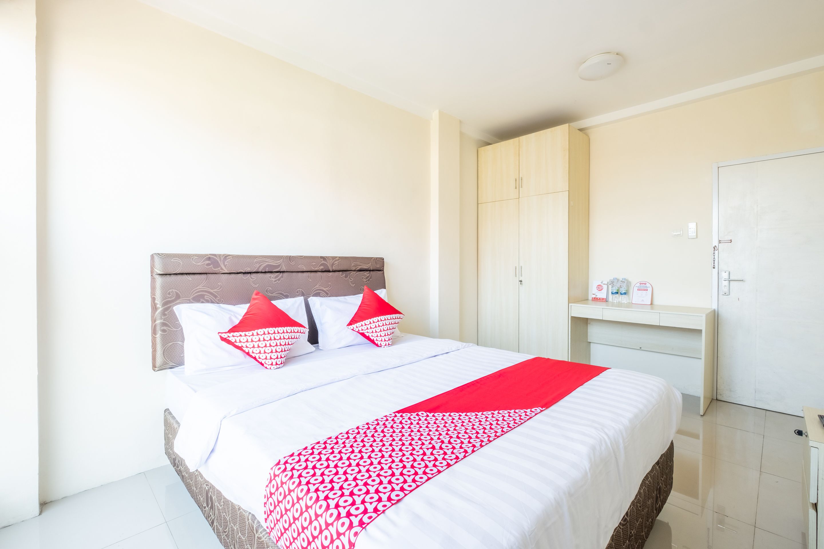 Une chambre d’hôtel avec un lit, une armoire et un bureau.