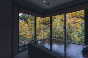 Un interior moderno con amplios ventanales que ofrecen vistas del follaje otoñal.